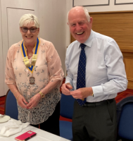 John hands over the Presidential chain to Elizabeth